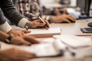 man writing in a notepad